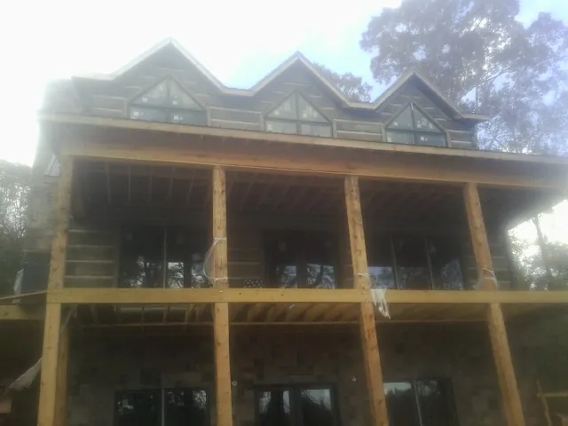 Dormers and porch framing on a large log home under construction — Roof Coating work by our crew in Ellijay