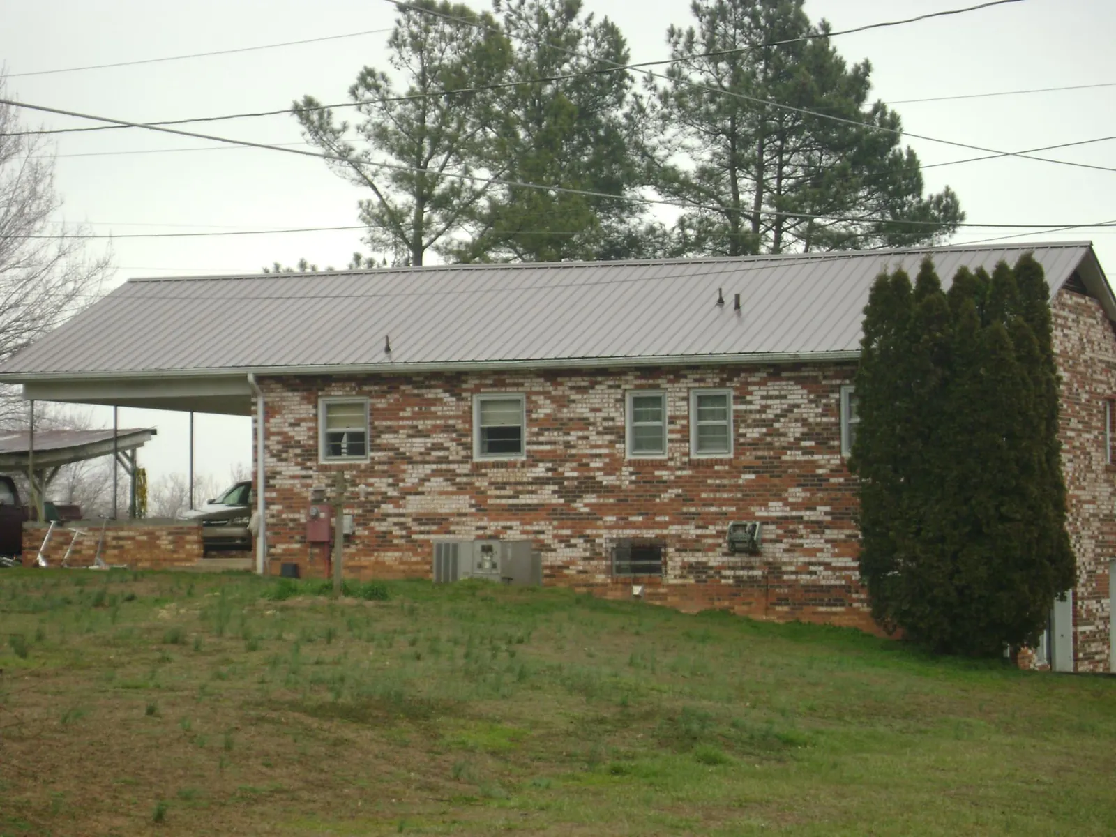 Gray metal roof on a brick split level home with a carport in Ellijay