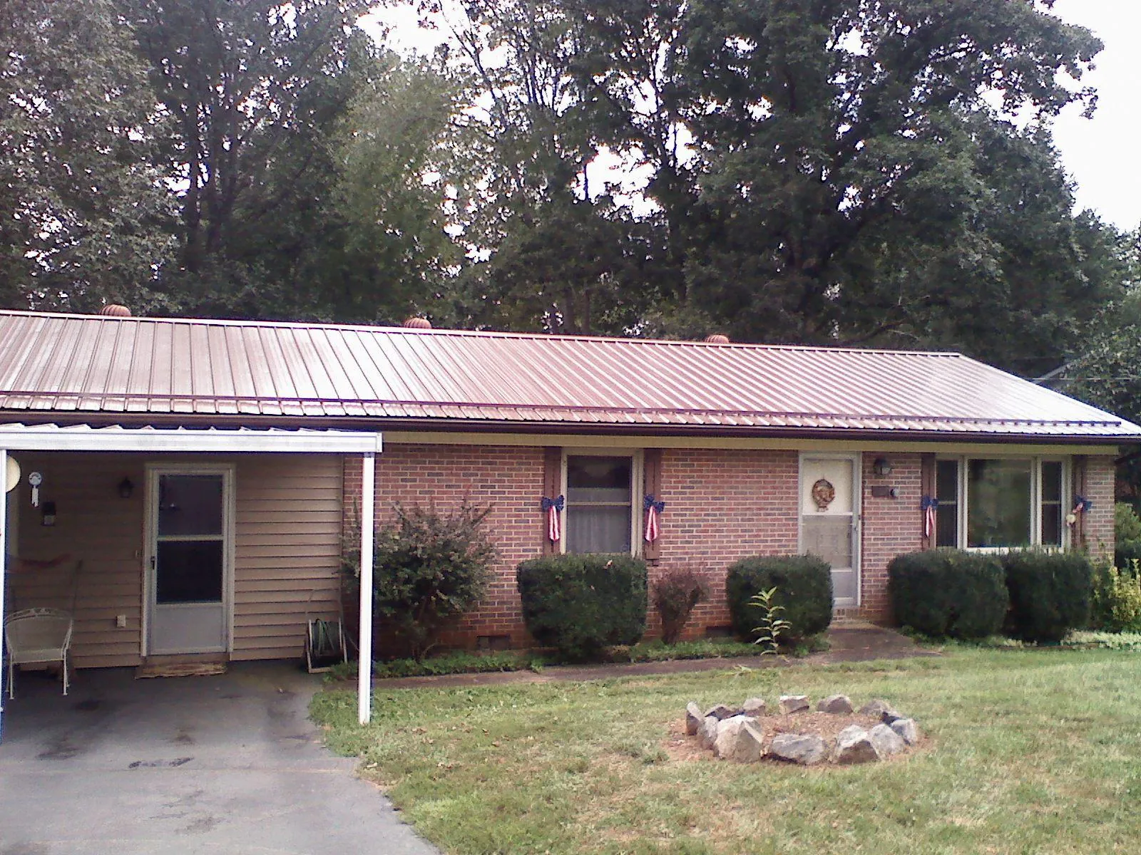 Bronze metal roof and carport on a brick ranch home — Roof Repair work by our crew in Ellijay